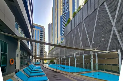 a swimming pool in a city with tall buildings at EasyGo - Chic 1BR in Damac Maison in Dubai