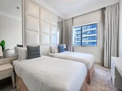 a hotel room with two beds and a couch at EasyGo - Chic 1BR in Damac Maison in Dubai