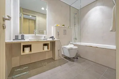 a bathroom with a sink and a toilet and a tub at 3 Bedroom - Pool Access - 7 mins to Dubai Mall - Sun Set View in Dubai