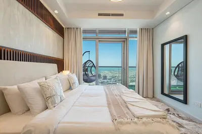 a bedroom with a large bed with a large window at 3 Bedroom - Pool Access - 7 mins to Dubai Mall - Sun Set View in Dubai