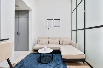 a living room with a couch and a table at Studio Haven with Pool, Tennis and Kid's Playground in Dubai