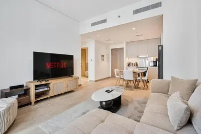 a living room with a couch and a tv at Elegant 1BR with Pool, Gym Access and Kid's Play Area in Dubai