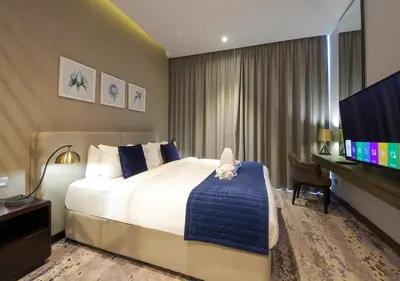 a hotel room with a bed and a flat screen tv at Burj Khalifa & Canal View LuxeStudio in DAMACPrive in Dubai