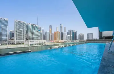 a large swimming pool with a view of a city at Luxurious One Bed Near Dubai Mall with Burj and Canal View in Dubai