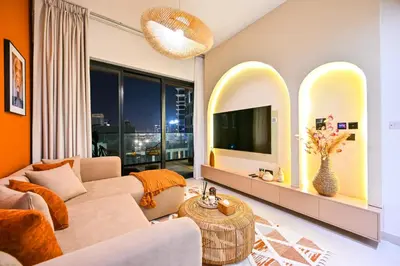 a living room with a couch and a tv at Luxurious One Bed Near Dubai Mall with Burj and Canal View in Dubai
