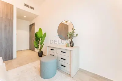 a room with a mirror and a dresser with a stool at Near Dubai Miracle Garden 1BR with Private Balcony, Orchid Residence, Al Barsha South by Deluxe Holiday Homes in Dubai