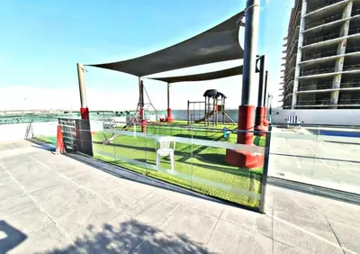 a pavilion with a picnic table and a playground at Near Dubai Miracle Garden 1BR with Private Balcony, Orchid Residence, Al Barsha South by Deluxe Holiday Homes in Dubai