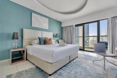 a bedroom with a large bed and a chair at GuestReady - Stylish home in Business Bay in Dubai