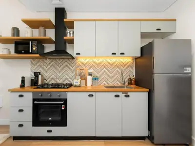 a kitchen with white cabinets and a refrigerator at Contemporary 1BR in Collective 2.0 Luxury and Comfort in Dubai