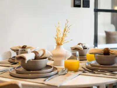 a table with plates and bowls and a glass of orange juice at Contemporary 1BR in Collective 2.0 Luxury and Comfort in Dubai
