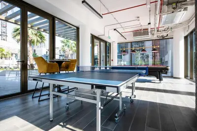 a ping pong table in a room with windows at New Build Luxury with Burj View at Peninsula 5, Business Bay in Dubai