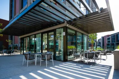 a group of tables and chairs in front of a building at New Build Luxury with Burj View at Peninsula 5, Business Bay in Dubai