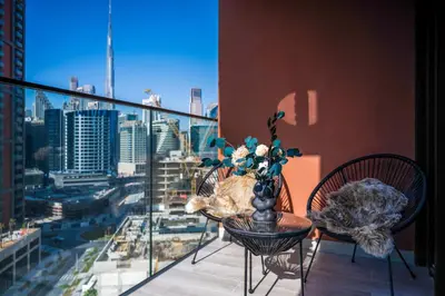 a table and chairs on a balcony with a view of a city at New Build Luxury with Burj View at Peninsula 5, Business Bay in Dubai