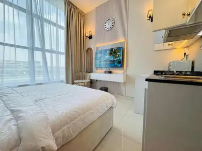 a bedroom with a bed and a kitchen with a clock at Al Manara Premium Deluxe Sheikh Zayed View Studio in Dubai