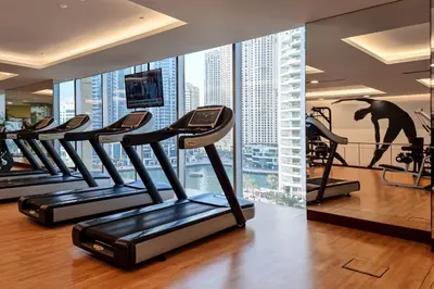 a gym with rows of treadmills in a building at JW Marriott Marina By Luxe Living Collection - Wane By Somiya Infinity Pool in Dubai