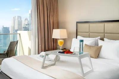 a hotel room with a bed with a tray of food on it at JW Marriott Marina By Luxe Living Collection - Wane By Somiya Infinity Pool in Dubai