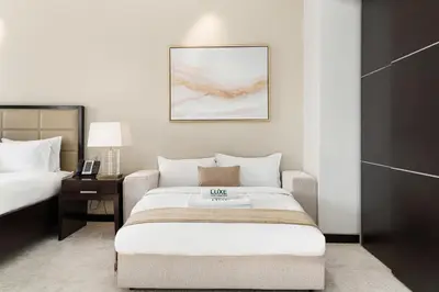 a hotel room with a bed and a table with a lamp at JW Marriott Marina By Luxe Living Collection - Wane By Somiya Infinity Pool in Dubai