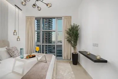 a white living room with a white couch and a window at Standpoint Tower by Luxe Living in Dubai