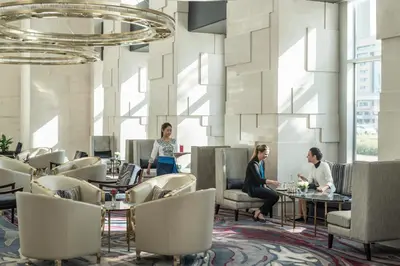 a group of people sitting at tables in a restaurant at Shangri-La Apartments in Dubai