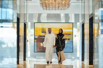 a man and a woman standing in front of a painting at Shangri-La Apartments in Dubai