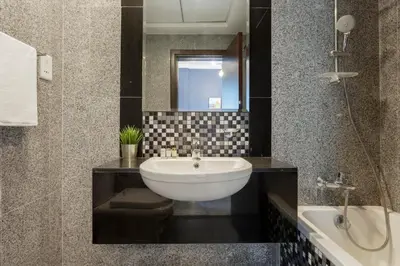 a bathroom with a white sink and a mirror at GuestReady - Modern Apartment with Gorgeous Views in Dubai