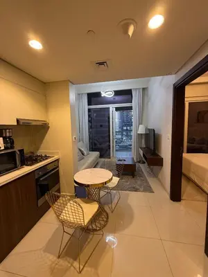 a kitchen and living room with a table and chairs at DAMAC Reva 5 mins Walk from Dubai mall in Dubai