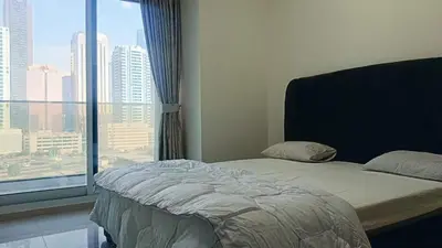 a bedroom with a bed and a large window at Burj Views 2 BHK Apartment in Dubai