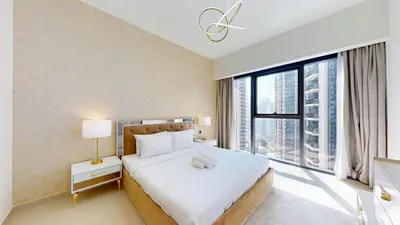 a bedroom with a large bed and a large window at Act One Act Two - Sophisticated Two Bedroom in Dubai