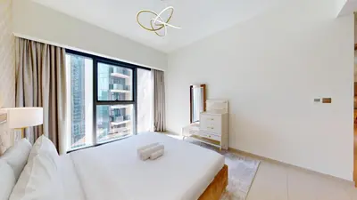 a white bedroom with a bed and a large window at Act One Act Two - Sophisticated Two Bedroom in Dubai