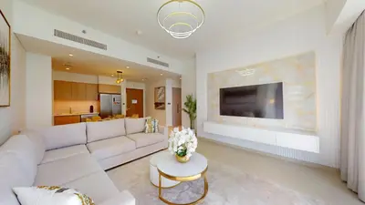 a living room with a white couch and a tv at Act One Act Two - Sophisticated Two Bedroom in Dubai