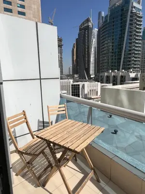 a wooden table and chair on the roof of a building at Marina Diamond in Dubai