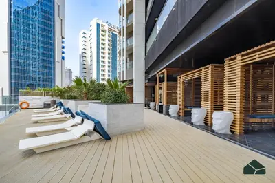 a row of white chairs on the roof of a building at Cozy Studio with City Views at Bayz by Danube by BMS in Dubai
