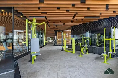 a gym with yellow exercise equipment in a building at Cozy Studio with City Views at Bayz by Danube by BMS in Dubai