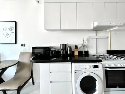 a kitchen with a washing machine and a stove at Homes2Retreat - Chic & Cozy Studio in Damac in Dubai
