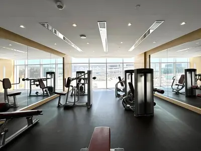 a gym with several treadmills and machines in a room at Homes2Retreat - Chic & Cozy Studio in Damac in Dubai