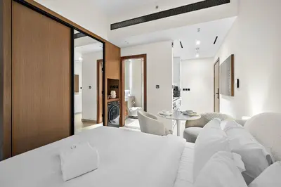 a living room with a white couch and a table at FIRST CLASS Studio Touch of Luxury & Comfort in Dubai
