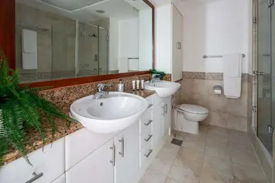 a bathroom with two sinks and a toilet at Frank Porter - Al Yass Tower in Dubai