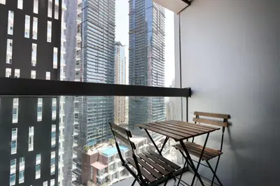 a table and chairs on a balcony with a view of a city at Livbnb-Spacious 2 BR in Dubai Marina with Balcony in Dubai