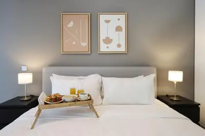 a bed with a tray of food on it with two lamps at Livbnb-Spacious 2 BR in Dubai Marina with Balcony in Dubai