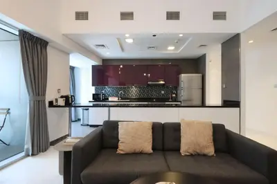 a living room with a couch and a kitchen at Livbnb-Spacious 2 BR in Dubai Marina with Balcony in Dubai