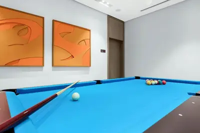 a pool table in a room with art on the wall at FIRST CLASS 2BR Burj Khalifa & Fountain view in Dubai