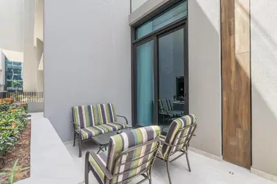 a patio with chairs and a table on a balcony at Modern Studio by Czechin JVC Prime Location in Dubai