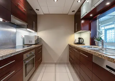 a large kitchen with wooden cabinets and a sink at Luxurious Studio in Downtown Dubai in Dubai