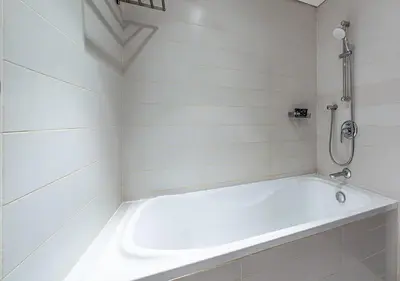 a white bathroom with a tub and a shower at Luxurious Studio in Downtown Dubai in Dubai
