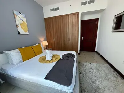 a bedroom with a bed with a yellow blanket on it at Spacious and Family Friendly l 3BHK Full Apartment Access in Dubai