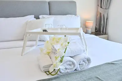 a white bed with towels and a table on it at Burj Khalifa View, Luxury Two-Bedroom Residence, PlayStation 5, Swimming Pool and Fitness Center in Dubai