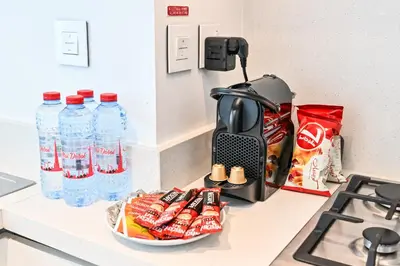 a counter top with a coffee maker and bottles of water at Burj Khalifa View, Luxury Two-Bedroom Residence, PlayStation 5, Swimming Pool and Fitness Center in Dubai