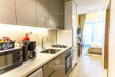 a kitchen with a sink and a stove at Modern Studio in Azizi Riviera, Meydan in Dubai