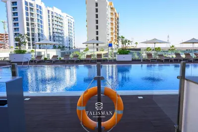 an orange kayak sitting next to a swimming pool at Modern Studio in Azizi Riviera, Meydan in Dubai