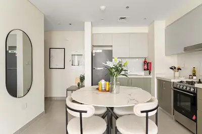 a kitchen with a round table and chairs in a kitchen at Silkhaus Cozy 1BDR at Forte Tower in Emaar Downtown in Dubai